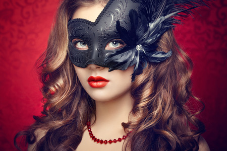Beautiful young woman in black mysterious  Venetian mask  Fashion photoの写真素材