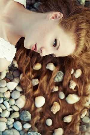 Beautiful young woman with unusual hairstyle on beach. Fashion photoの写真素材