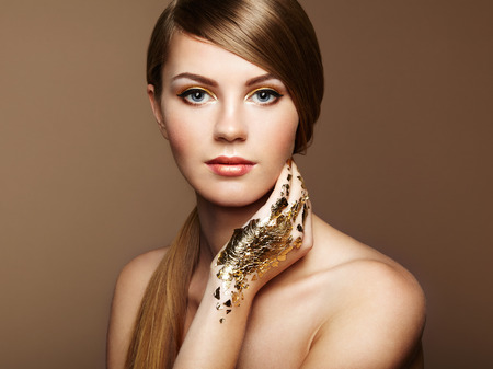 Magic woman portrait in gold. Blonde girl. Perfect make-up. Fashion photoの写真素材