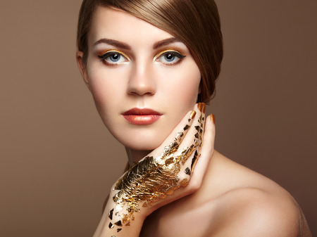 Magic woman portrait in gold. Blonde girl. Perfect make-up. Fashion photoの写真素材