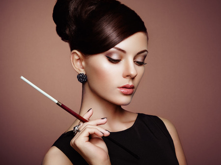 Portrait of beautiful sensual woman with elegant hairstyle.  Woman with cigarette Perfect makeup. Fashion photoの写真素材