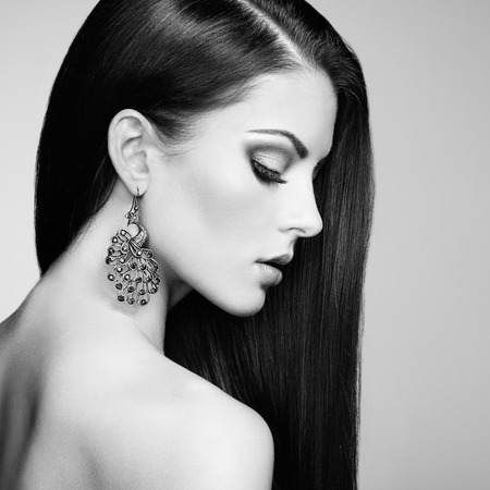 Portrait of beautiful brunette woman with earring. Perfect makeup. Fashion photo. Black and Whiteの写真素材