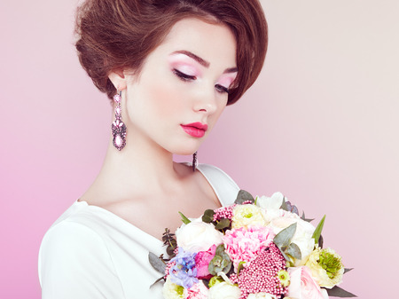 Woman with bouquet of flowers in her hands. Flowers. Spring. Bride. March 8. Fashion photoの写真素材