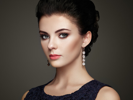 Fashion portrait of young beautiful woman with jewelry. Brunette girl. Perfect make-up.  Beauty style woman with diamond accessoriesの写真素材