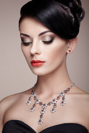 Fashion portrait of young beautiful woman with jewelry. Brunette girl. Perfect make-up.  Beauty style woman with diamond accessoriesの写真素材