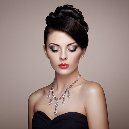 Fashion portrait of young beautiful woman with jewelry. Brunette girl. Perfect make-up.  Beauty style woman with diamond accessoriesの写真素材