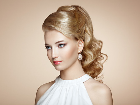 Fashion portrait of young beautiful woman with jewelry and elegant hairstyle. Blonde girl with long wavy hair. Perfect make-up.  Beauty style woman with diamond accessoriesの写真素材