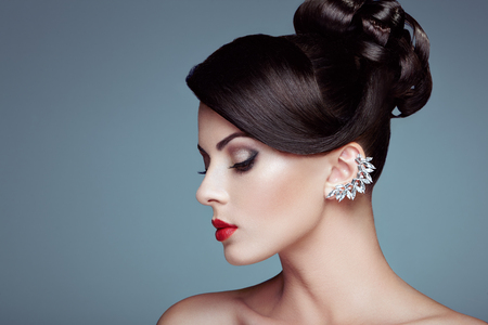 Fashion portrait of young beautiful woman with jewelry. Brunette girl. Perfect make-up.  Beauty style woman with diamond accessoriesの写真素材