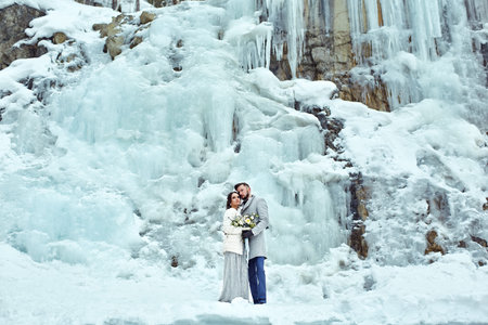 Happy couple hugging on rock on the background of nature. Fashion style. Family outdoors. Man and woman. Bride and groomの写真素材