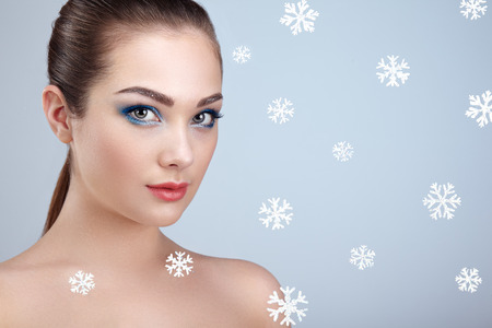Beauty portrait of young beautiful woman over snowy. Christmas background. New yaer holidays and people conceptの写真素材