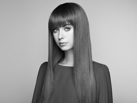 Portrait of beautiful woman with red hair. Colored long haircut. Perfect make-up. Girl in elegant violet dress. Red wig. Fashion photo. Black and White photoの写真素材