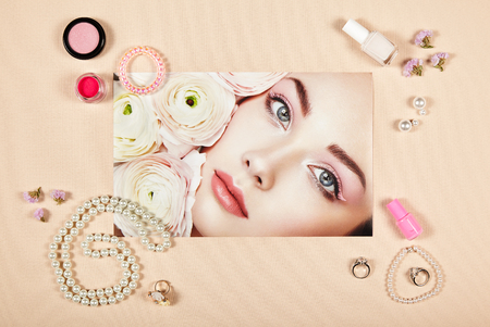 Fashion lady accessories collage. Falt Lay. Beauty photography. Make-Up brushes. Jewelry and nail polish. Portrait of beautiful young woman with flowersの写真素材