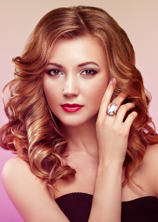 Blonde woman with long and volume shiny wavy hair . Beautiful model with curly hairstyle.の写真素材