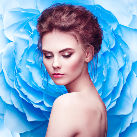 Beautiful Woman on the Background of a Large Flower. Beauty Summer Model Girl with Blue Peony. Young Woman with elegant Hairstyle and Makeup. Fashion Photoの写真素材