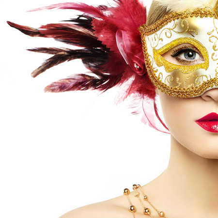 Beautiful young Woman in Mysterious Golden Venetian Mask. Fashion photo. Masquerade Mask with Red Feathersの写真素材