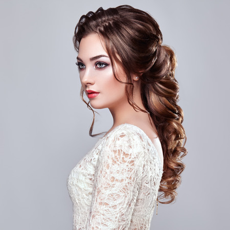 Brunette Woman with Long and shiny Curly Hair. Beautiful Model Lady with Curly Hairstyle. Care and Beauty Hair products. Care and Beauty of Hairの写真素材