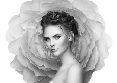 Beautiful woman on the background of a large flower. Beauty summer model girl with peony. Young woman with elegant hairstyle and makeup. Fashion photoの写真素材