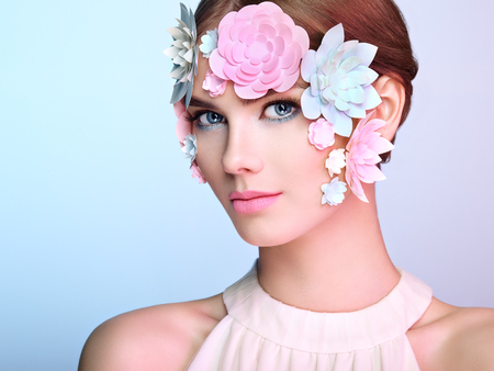 Face of Beautiful Woman Decorated with Flowers. Perfect Makeup. Beauty Fashion Model Woman Face perfect Skin. Paper Flowersの写真素材