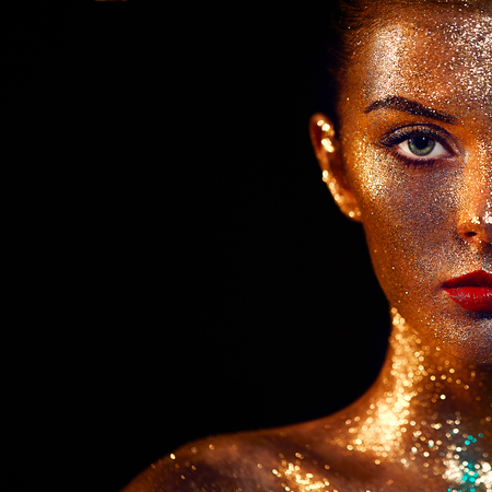 Portrait of Beautiful Woman with Sparkles on her Face. Girl with Art Make-Up in Color Light. Fashion Model with Colorful Makeupの写真素材