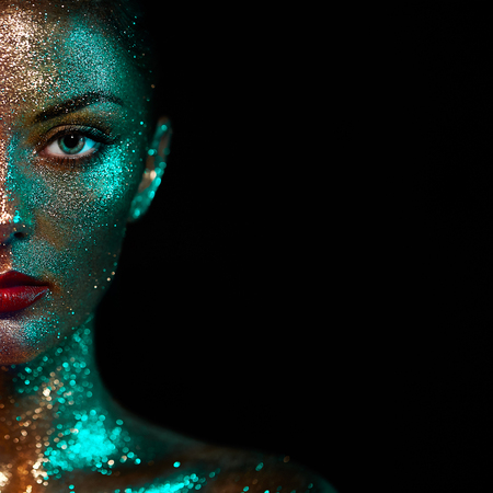 Portrait of Beautiful Woman with Sparkles on her Face. Girl with Art Make-Up in Color Light. Fashion Model with Colorful Makeupの写真素材