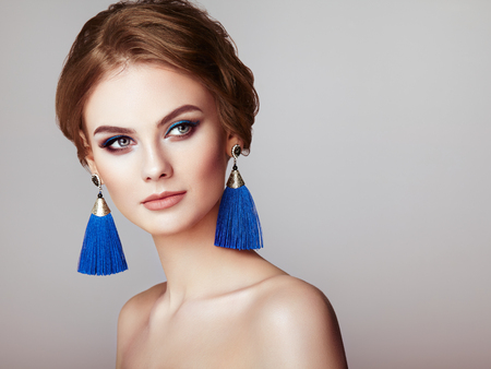 Beautiful Woman with Large Earrings Tassels jewelry Blue color. Perfect Makeup and Elegant Hairstyle. Blue Make-up Arrowsの写真素材