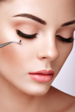 Beautiful Woman with Extreme Long False Eyelashes. Eyelash Extensions. Makeup, Cosmetics. Beauty, Skincare. Woman Glues Eyelashesの写真素材