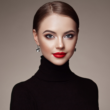 Beautiful Young Woman with Clean Fresh Skin. Perfect Makeup. Beauty Fashion. Red Lips. Cosmetic Eyeshadow. Smooth Hair. Girl in Black Turtleneckの写真素材