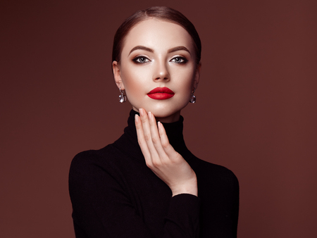 Beautiful Young Woman with Clean Fresh Skin. Perfect Makeup. Beauty Fashion. Red Lips. Cosmetic Eyeshadow. Smooth Hair. Girl in Black Turtleneckの写真素材