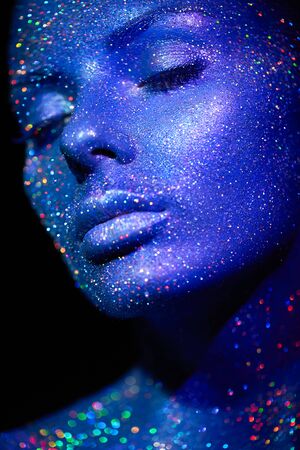 Fashion model woman in blue bright sparkles and neon lights posing in studio.  Portrait of beautiful sexy woman. Art design colorful glitter glowing make upの写真素材