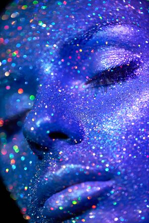 Fashion model woman in blue bright sparkles and neon lights posing in studio.  Portrait of beautiful sexy woman. Art design colorful glitter glowing make upの写真素材