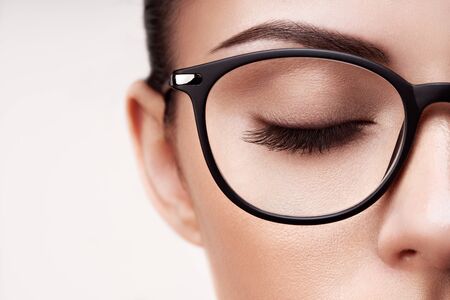 Female eye with long eyelashes in eyeglasses. Model in glasses. Vision correction. Poor eyesight. Spectacle frame. Makeup, cosmetics, beauty. Close up, macroの写真素材