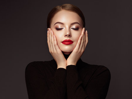 Beautiful Young Woman with Clean Fresh Skin. Perfect Makeup. Beauty Fashion. Red Lips. Cosmetic Eyeshadow. Smooth Hair. Girl in Black Turtleneckの写真素材