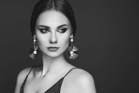 Brunette Girl with Long and shiny Smooth Hair. Beauty Fashion. Eyelashes. Cosmetic Eyeshadow. Care and Beauty Hair products. Perfect Make-Up and Jewelryの写真素材