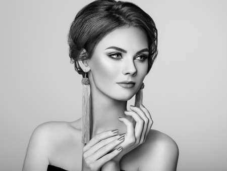 Beautiful Woman with Large Earrings Tassels jewelry. Perfect Makeup and Elegant Hairstyle. Nails manicureの写真素材