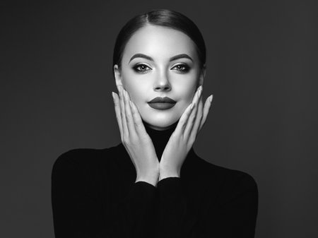 Beautiful Young Woman with Clean Fresh Skin. Perfect Makeup. Beauty Fashion. Cosmetic Eyeshadow. Girl in Black Turtleneck. Black and white photoの写真素材
