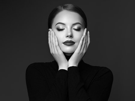 Beautiful Young Woman with Clean Fresh Skin. Perfect Makeup. Beauty Fashion. Cosmetic Eyeshadow. Girl in Black Turtleneck. Black and white photoの写真素材