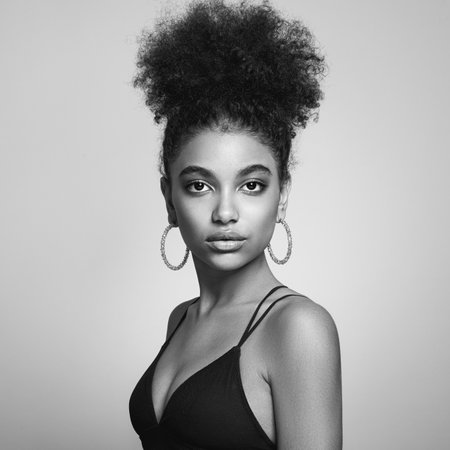 Beautiful smiling girl with curly hairstyle stock photo Women, African Ethnicity, Fashion Model, One Woman Only. Black and white photoの写真素材