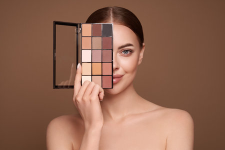 Beauty woman with eye shadow makeup palette. Model with healthy perfect skin, close up portrait. Cosmetology, beauty and spaの写真素材