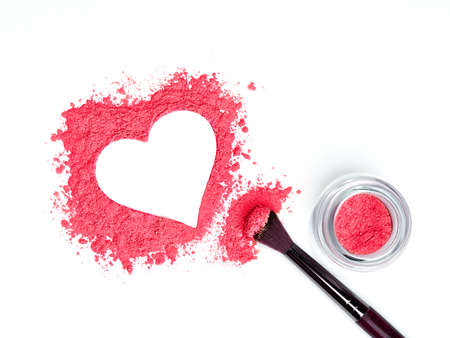 Valentine's Day background. Beige powder eye shadow scattered in the shape of heart. Isolated on white background. Cosmetic productsの写真素材