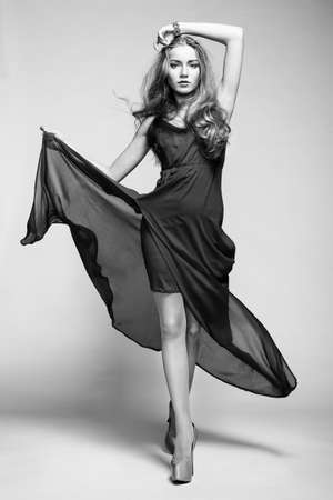 Fashion photo of young magnificent woman in black dress. Studio black and white photoの写真素材