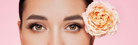 Portrait beautiful young woman with clean fresh skin. Model with healthy skin, close up portrait. Cosmetology, beauty and spa. Girl with a rose flowerの写真素材