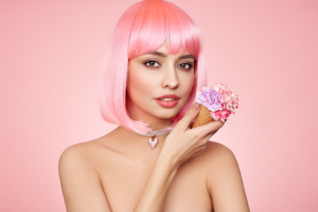 Beauty model portrait with pink hair. Bob short Haircut. Beautiful glamorous girl with flower ice creamの写真素材
