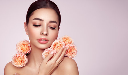 Portrait beautiful young woman with clean fresh skin. Model with healthy skin, close up portrait. Cosmetology, beauty and spa. Girl with a rose flowerの写真素材