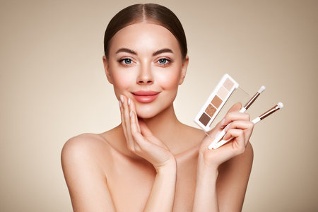 Beauty woman with eye shadow makeup palette. Model with healthy perfect skin, close up portrait. Cosmetology, beauty and spaの写真素材