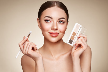 Beauty woman with eye shadow makeup palette. Model with healthy perfect skin, close up portrait. Cosmetology, beauty and spaの写真素材