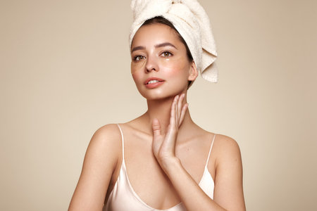 A young beautiful smiling woman with cosmetic patches on her eyes. Cosmetic procedures skin care around the eyes. Perfect healthy facial skinの写真素材