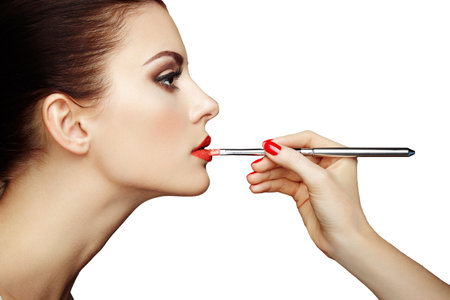 Makeup artist applies lipstick. Beautiful woman face. Perfect makeupの写真素材