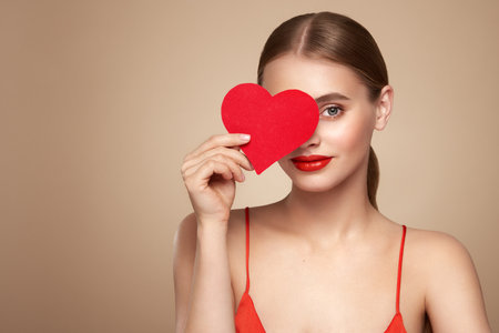 Beautiful young woman holding an artificial red heart. Valentine's Day - Holiday, Women, Valentine Card, One Woman Only, Heart Shapeの写真素材