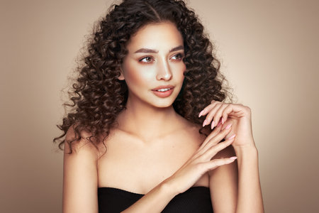 Fashion studio portrait of beautiful smiling woman with afro curls hairstyle. Fashion and beautyの写真素材