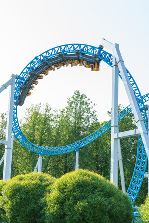 Roller coaster Ride against blue sky. Roller coaster in the amusement park. Cheerful entertainments in park of attractionsの写真素材